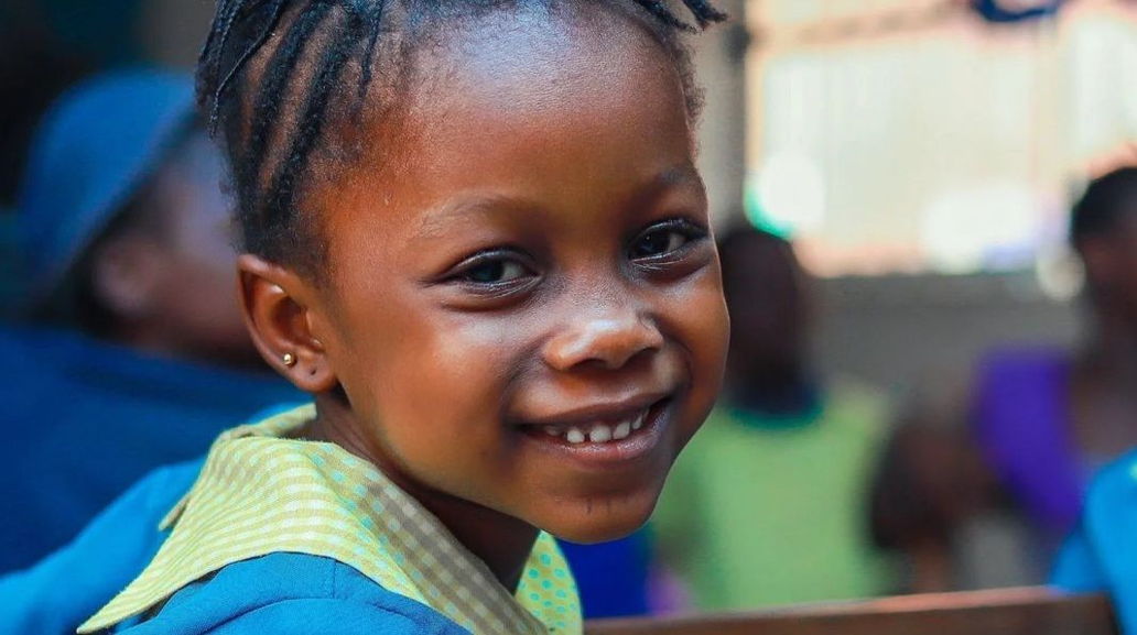 Smiling child supported by the Slum2School Africa and First Cut Bacon education partnership