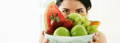 Model looking over large bowl of fruit - you can only see her eyes, forehead and dark hair