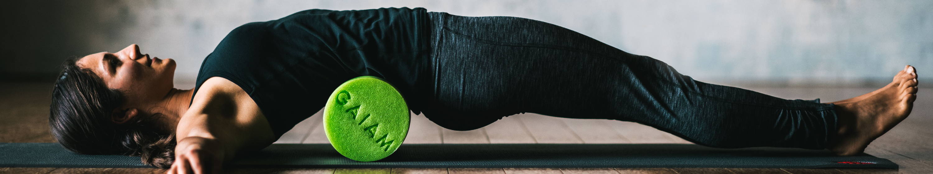 Woman laying on green foam roller