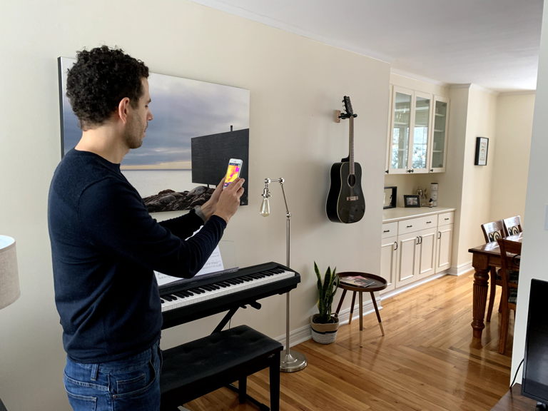 man holding smartphone reading temperature of dining room