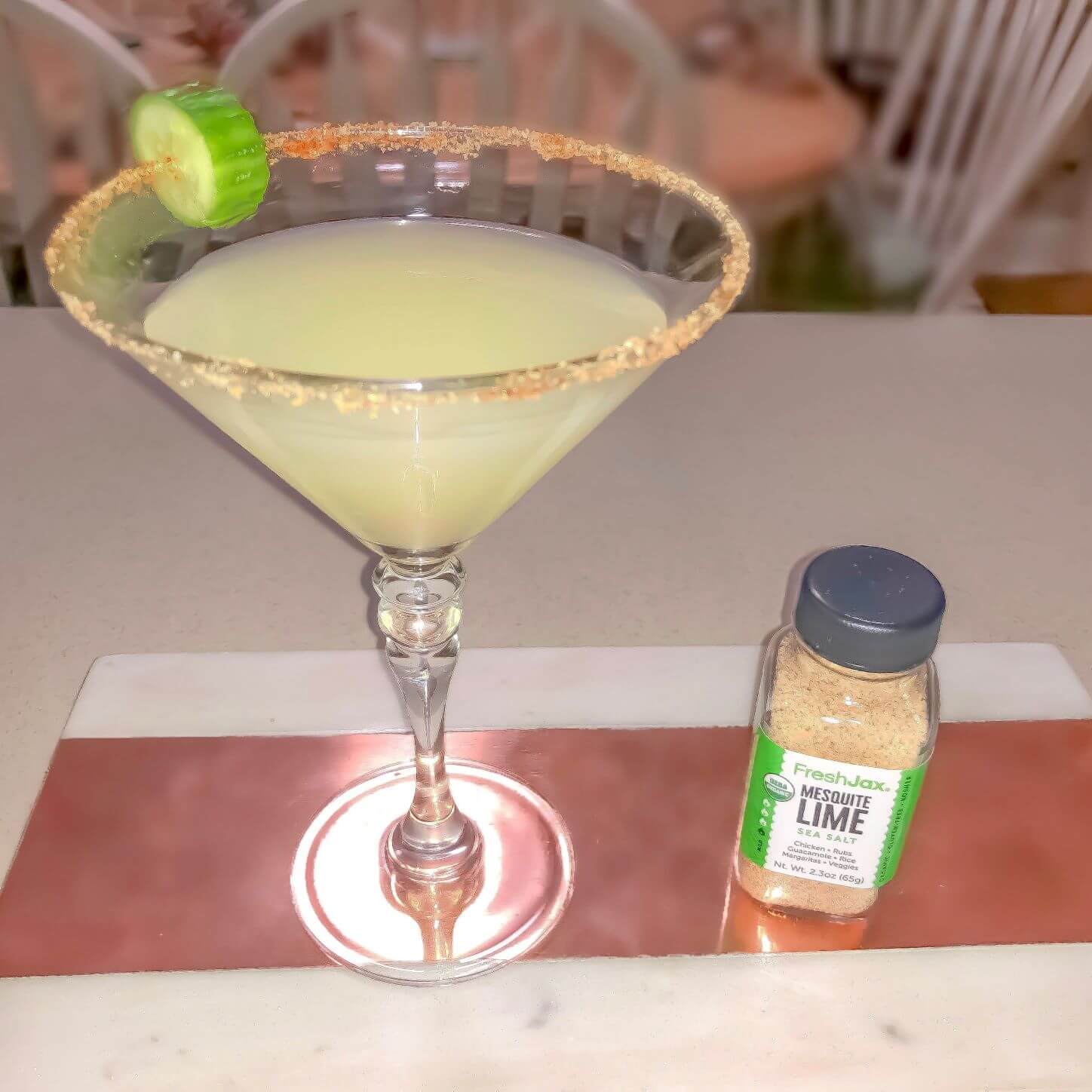 A margarita next to a small bottle of FreshJax Organic Mesquite Lime Sea Salt.