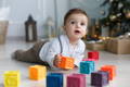 Baby playing with squeaky blocks on the floor