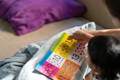Toddler reading a Montessori counting book with colorful numbers and illustrations
