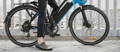 Eine Person sitzt auf einem blau-schwarzen E-Bike
