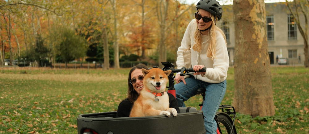A women with a cargo bike a friend and a dog