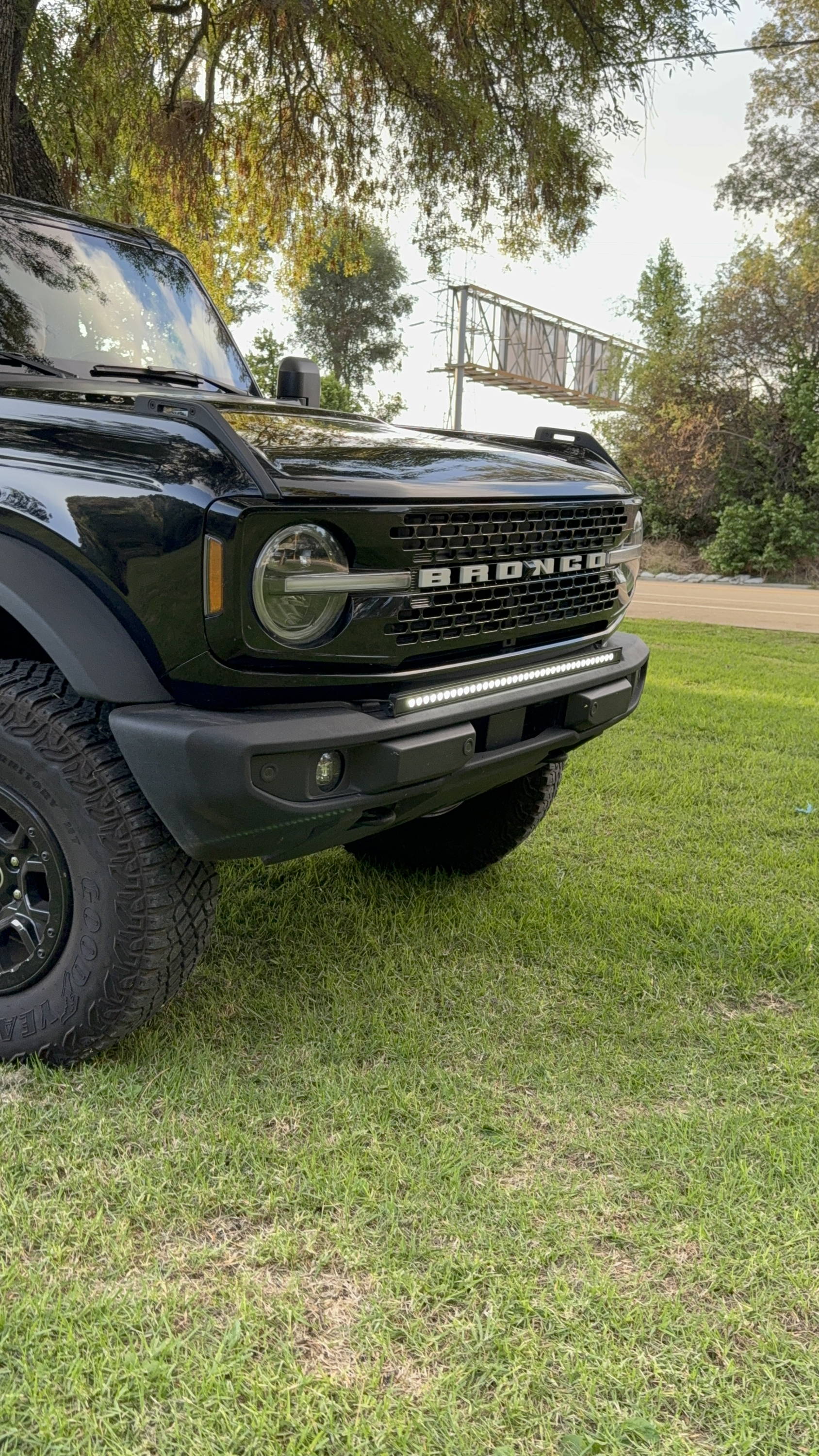 black ford bronco with white light bar on top of standard bumper