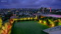 Wide angle shot of a garden illuminated with Garden Lighting by Havit, with the cityscape as the background