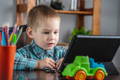 Little boy looking at a tablet screen. 