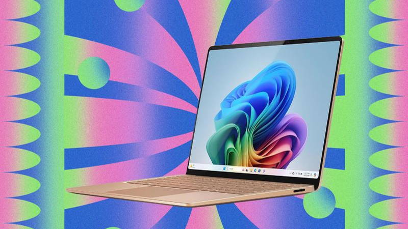 Slim golden laptop open with abstract art on the screen