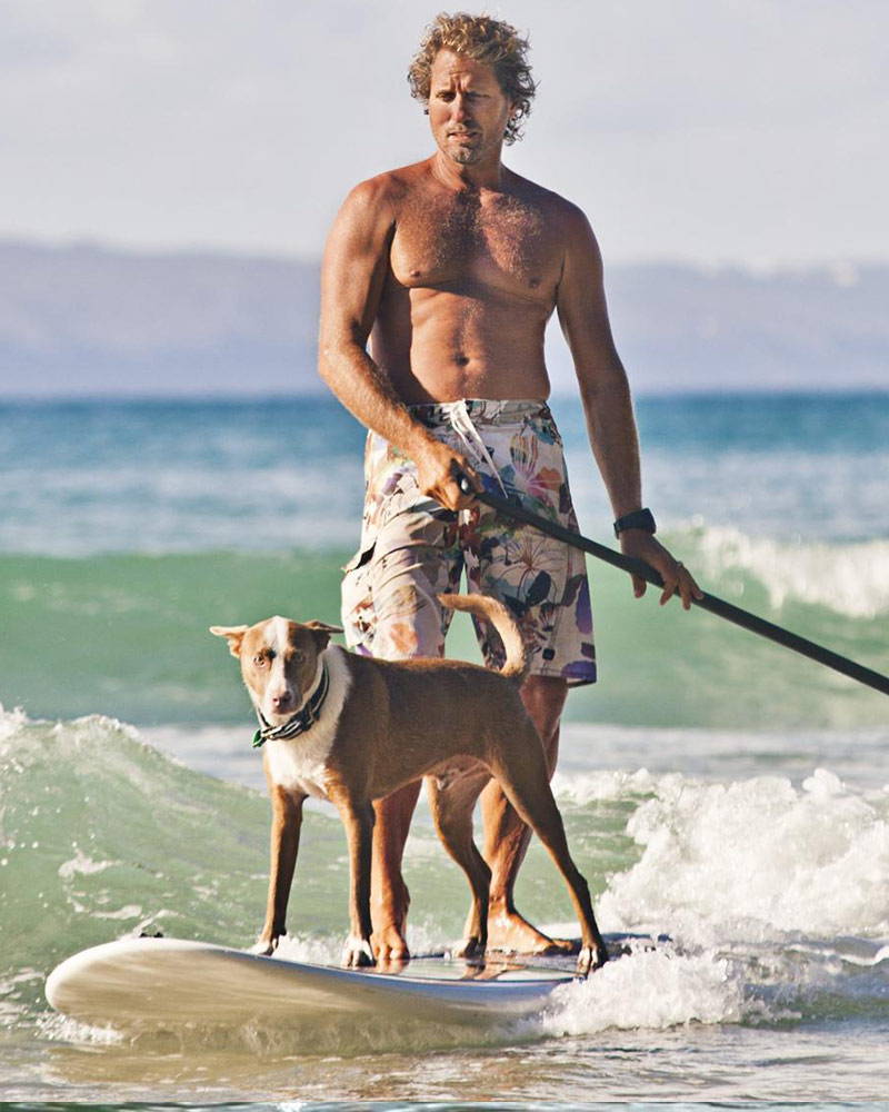 Chris de aboitiz surfing with his dog