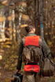 Man in the woods wearing an isle royale pack with a windigo signal bag and sawbill bag attached to the top and bottom.