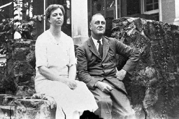 Eleanor and Franklin Roosevelt, sitting close together with serious looks, looking ahead.