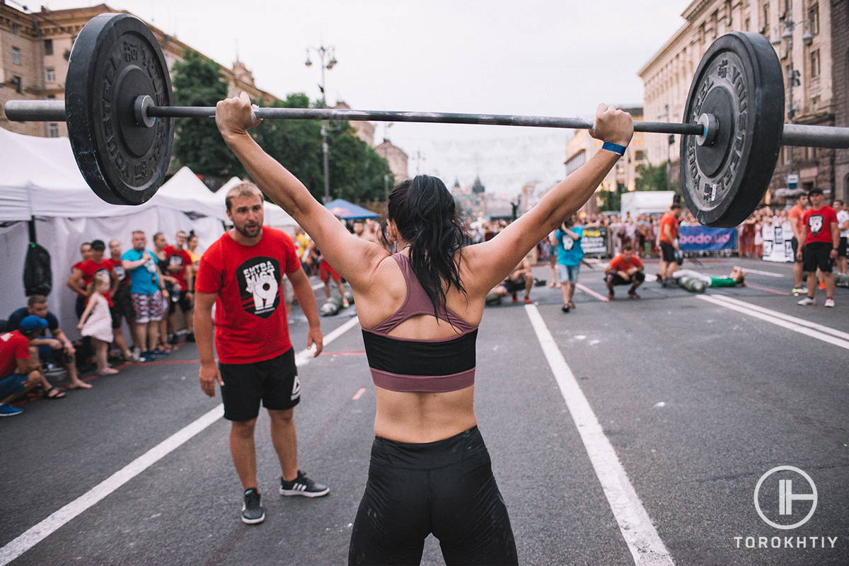 female athlete with barbell on the street