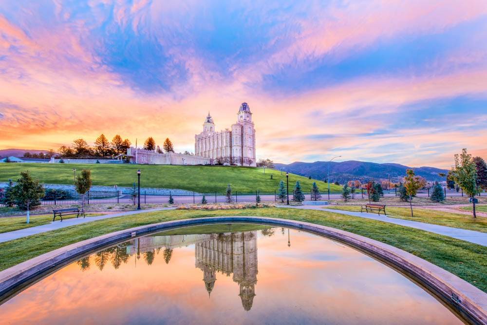 Photo of the Manti Temple from across a wide reflection pool. 