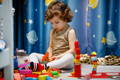 Little boy playing with Montessori toys in his playroom.