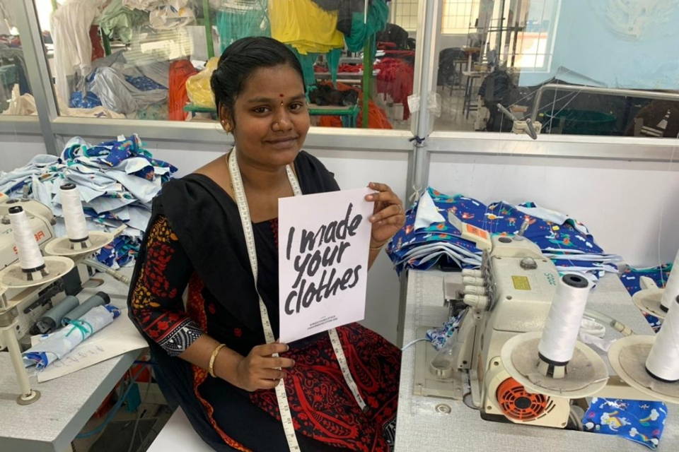 Image of lady holding a sign saying "I made your clothes"