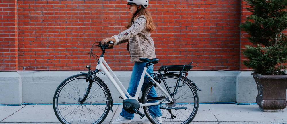 Woman walking alongside Gazelle Medeo electric bike
