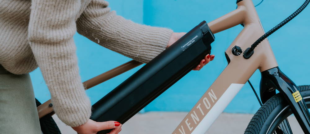 Someone removing the battery from an Aventon e-bike