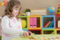 Child using a Montessori activity board to sort colorful shapes