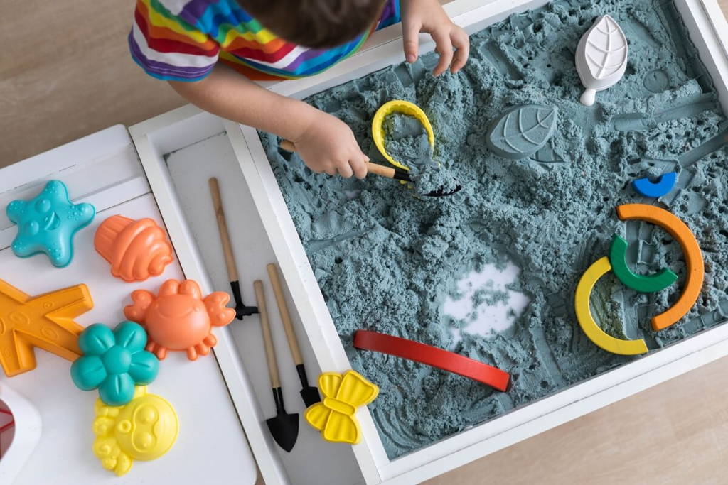 Boy playing with a colorful sensory bin.