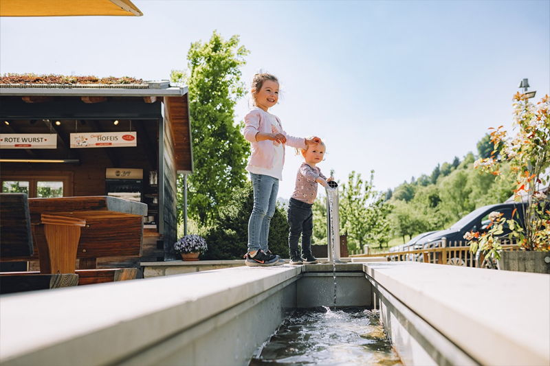 Kinder spielen an der Wasserstelle