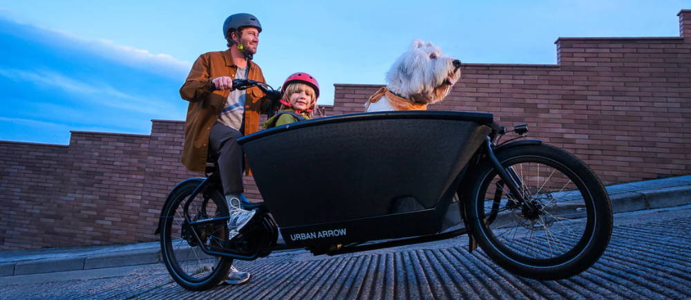 Dad and child and dog in Urban Arrow electric cargo bike