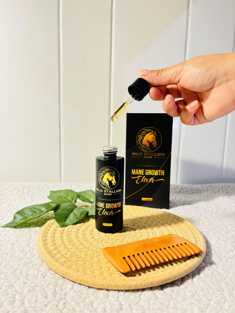 A dropper of Mane Growth Elixir held over the bottle
