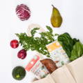 Einkaufstüte vor weißem Hintergrund mit Gemüse und Obst