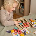 Wooden Montessori Brain Blocks featuring a sliding board, colorful wooden pieces, and play cards. 
