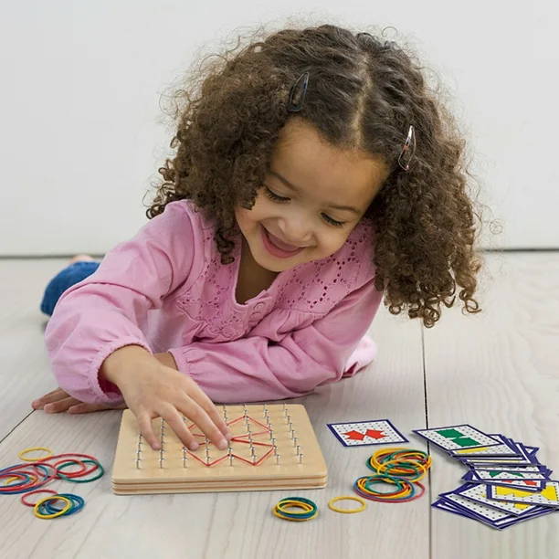 Little girl smiling while playing with a Montessori Wooden Geoboard.