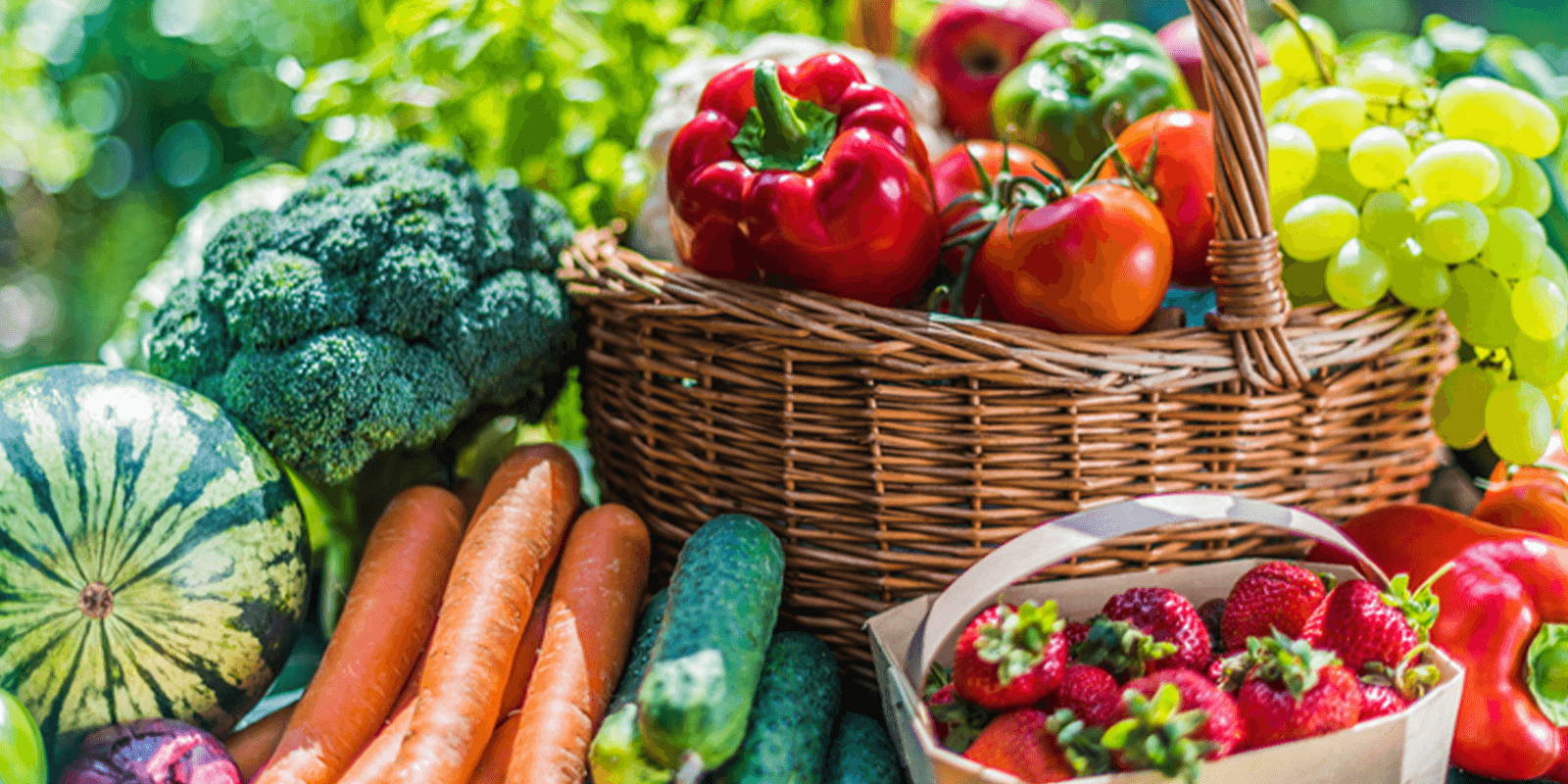 Basket filled and surrounded by fruits and vegetables.