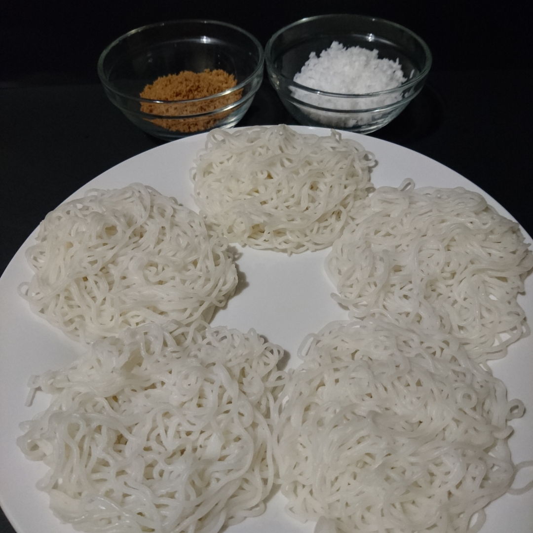 Idiyappam served with grated coconut and brown sugar.