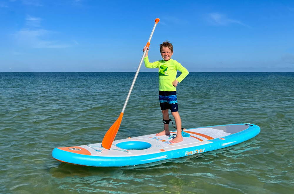 A boy is paddleboarding