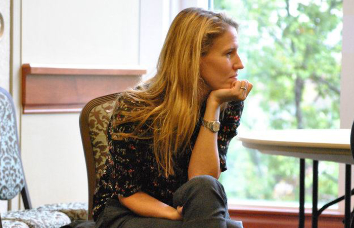 Jennifer listening very intently to someone off camera during a conference.