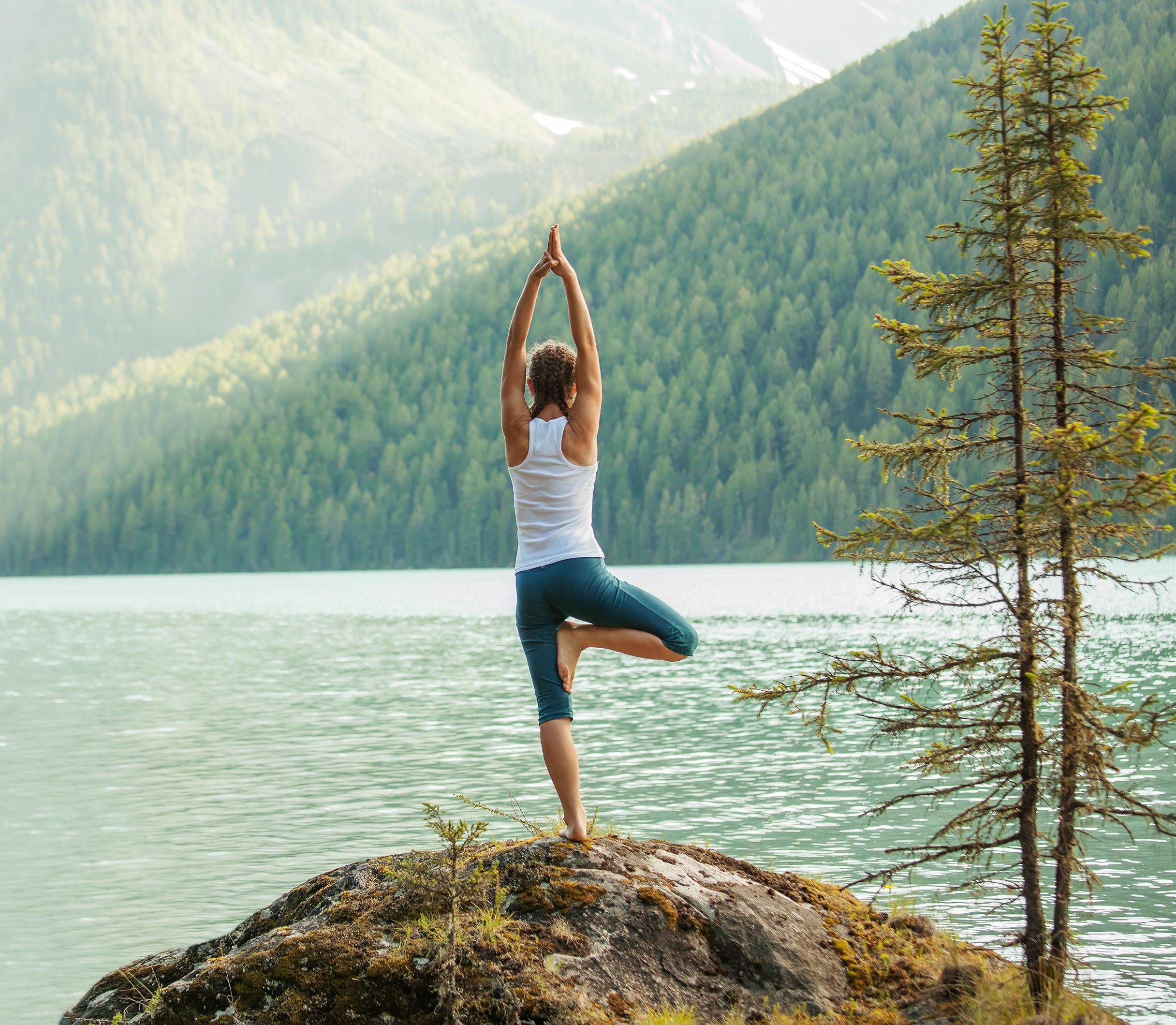 Woman doing yoga by lake