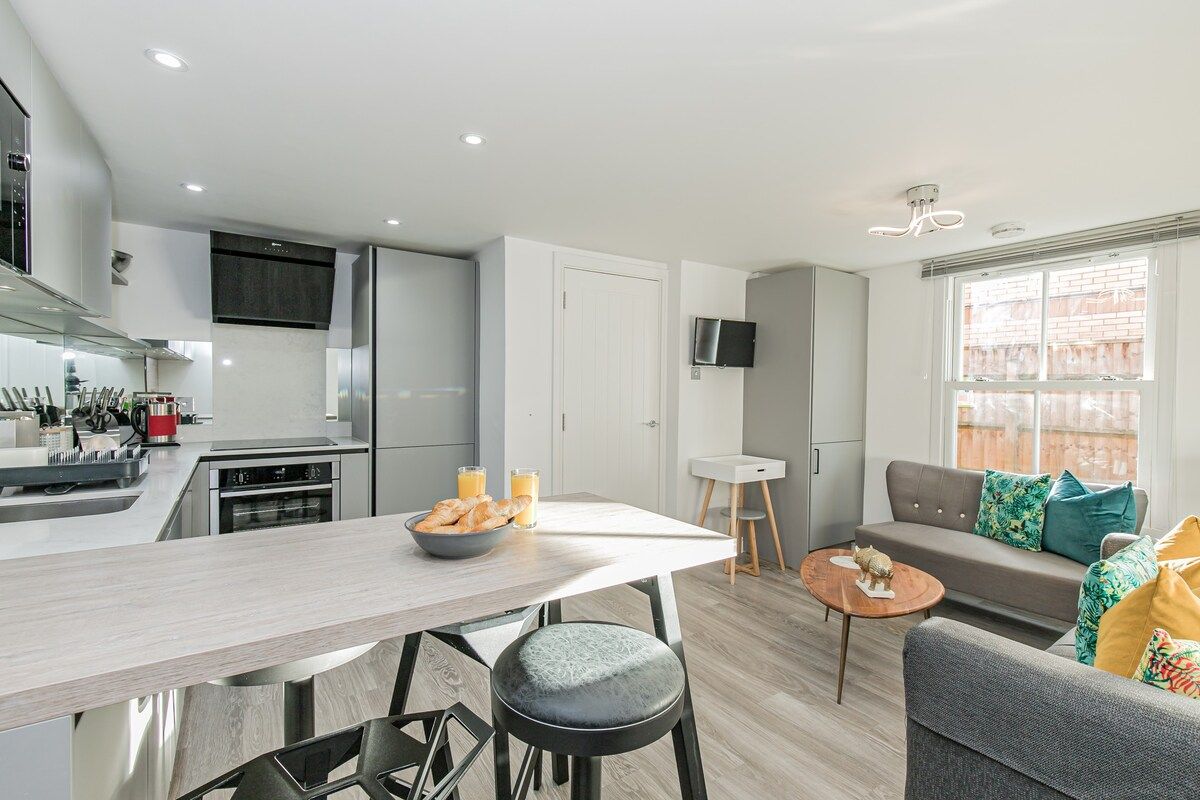 Modern apartment with open plan kitchen with breakfast bar and two sofas