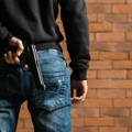 criminal male holding firearm behind his back man_holding_firearm_behind_back