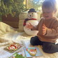 Little girl smiling while looking at her Montessori Toddler Christmas Puzzles.