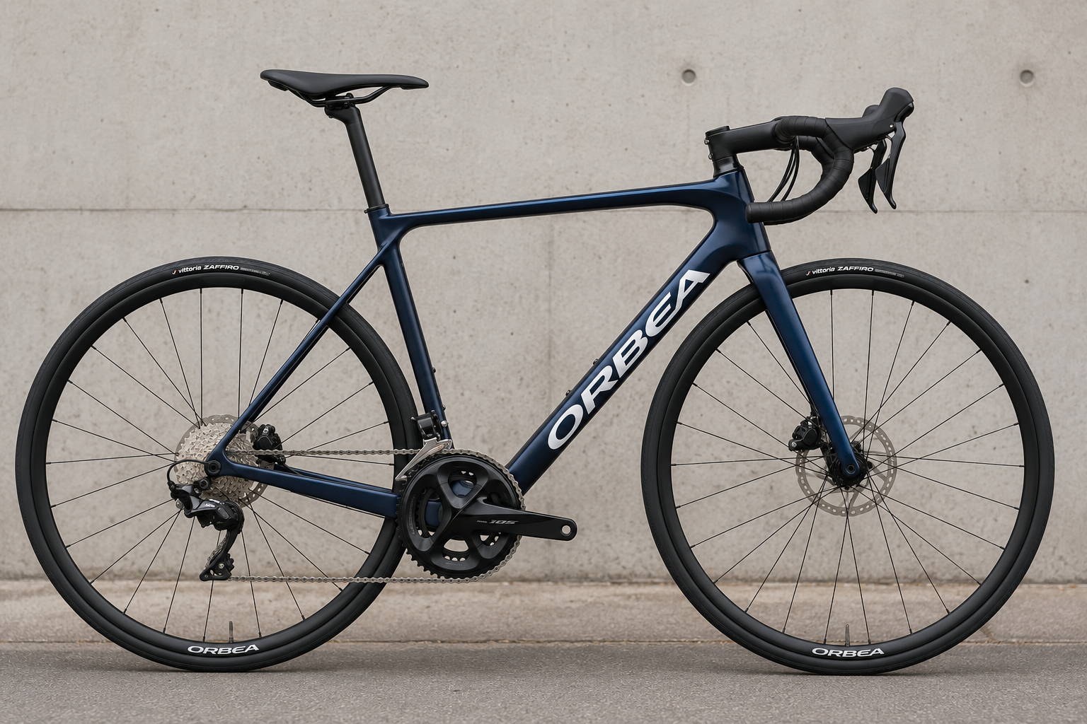 Orbea Orca M30 carbon racefiets met Shimano 105, schijfremmen en donkerblauw frame tegen een betonnen achtergrond