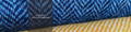 Logo tisserand indépendant de Harris Tweed Westend Cottage Tweeds avec deux étoffes de Harris Tweed de couleur bleu et jaune à motif à chevrons