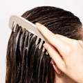 comb brushing through damp hair at the scalp
