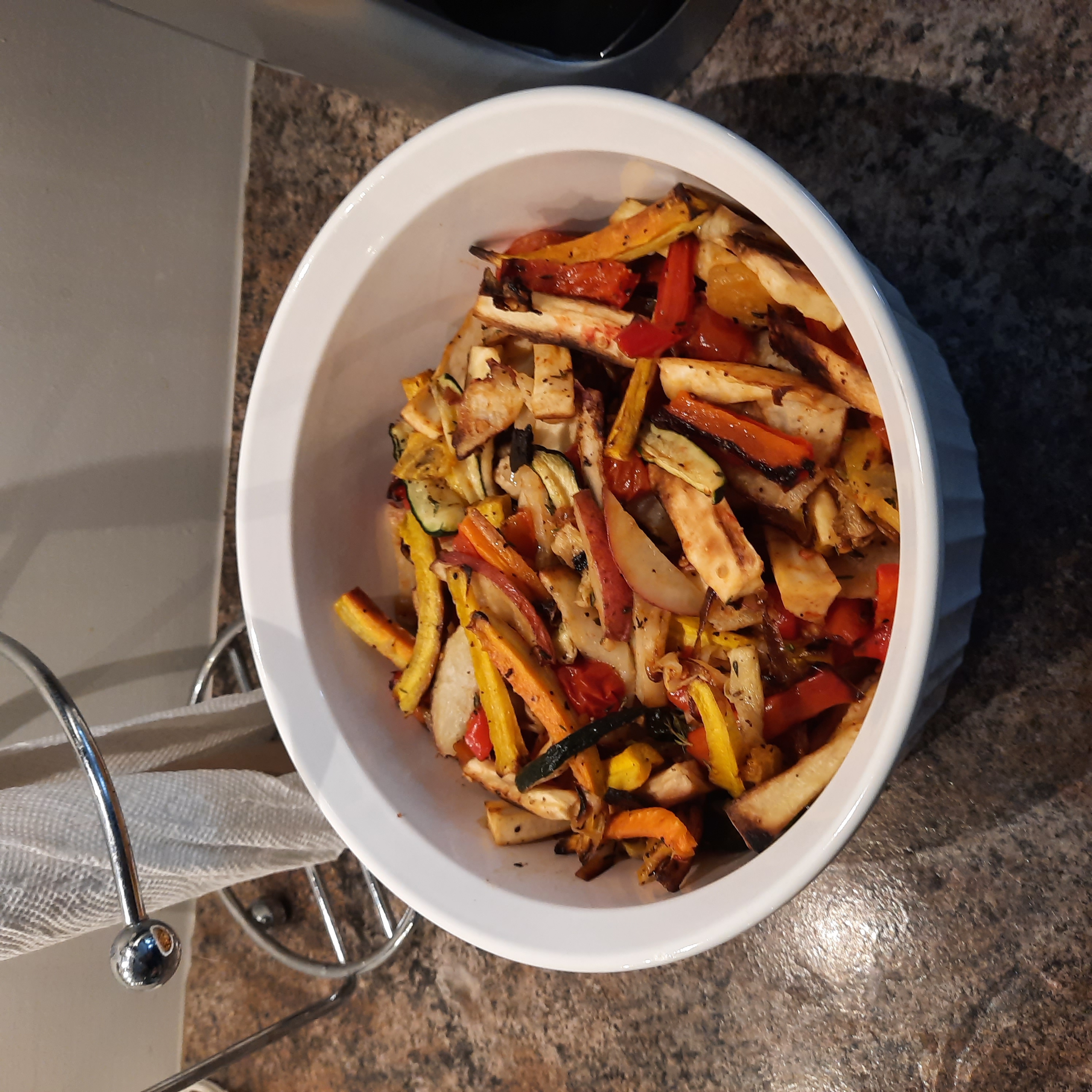 Roasted vegetable in a white baking dish on a kitchen counter