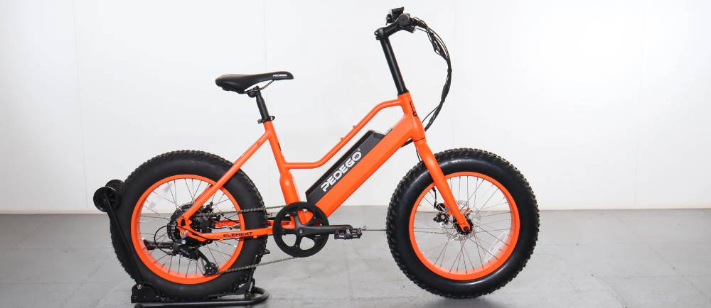 an orange pedego electric fat tire bike