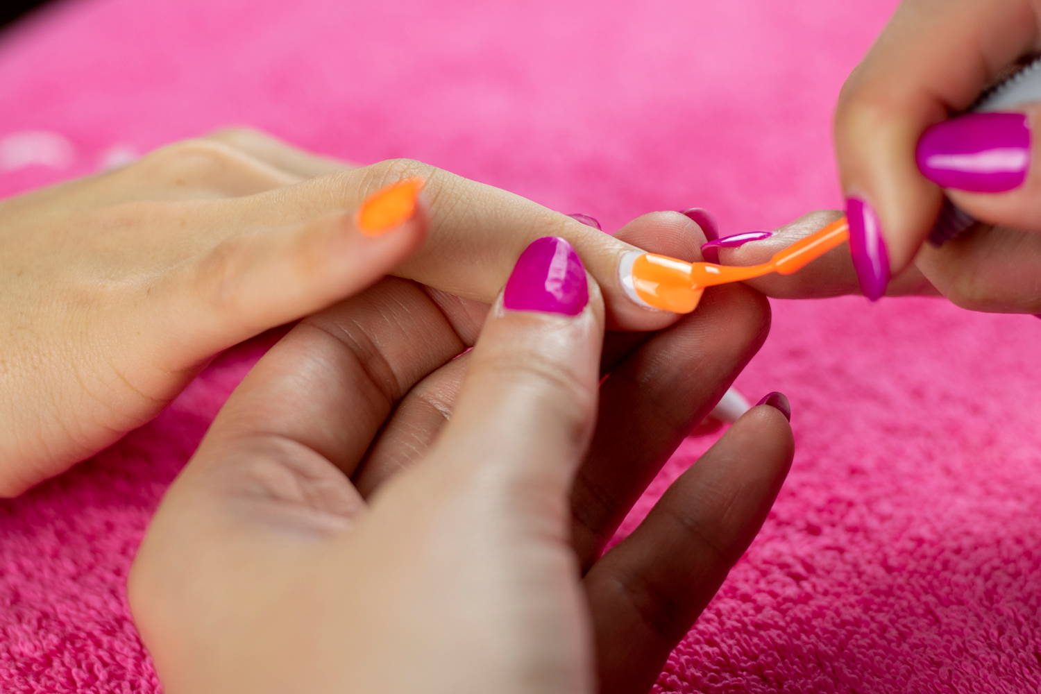 ORLY Melt Your Popsicle nail polish being painted onto nails to create pumpkin nails
