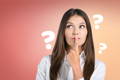 woman with finger over her mouth looking up with question marks around her head - is collagen vegan?