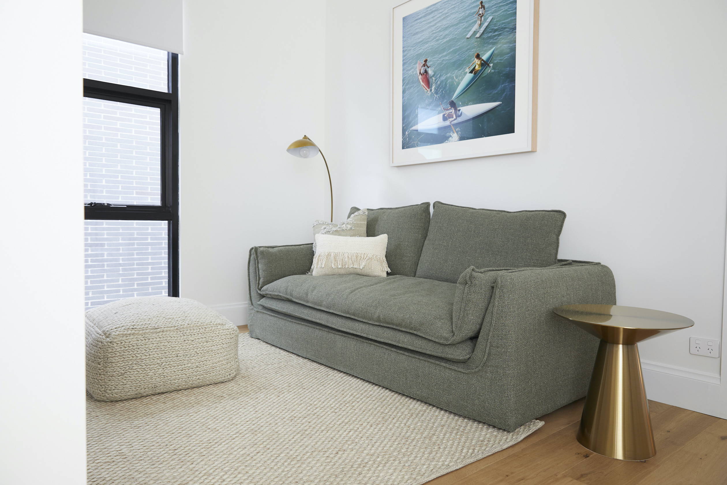 A TV-Mirror hanging on the wall of a coastal, elegant bedroom setting 