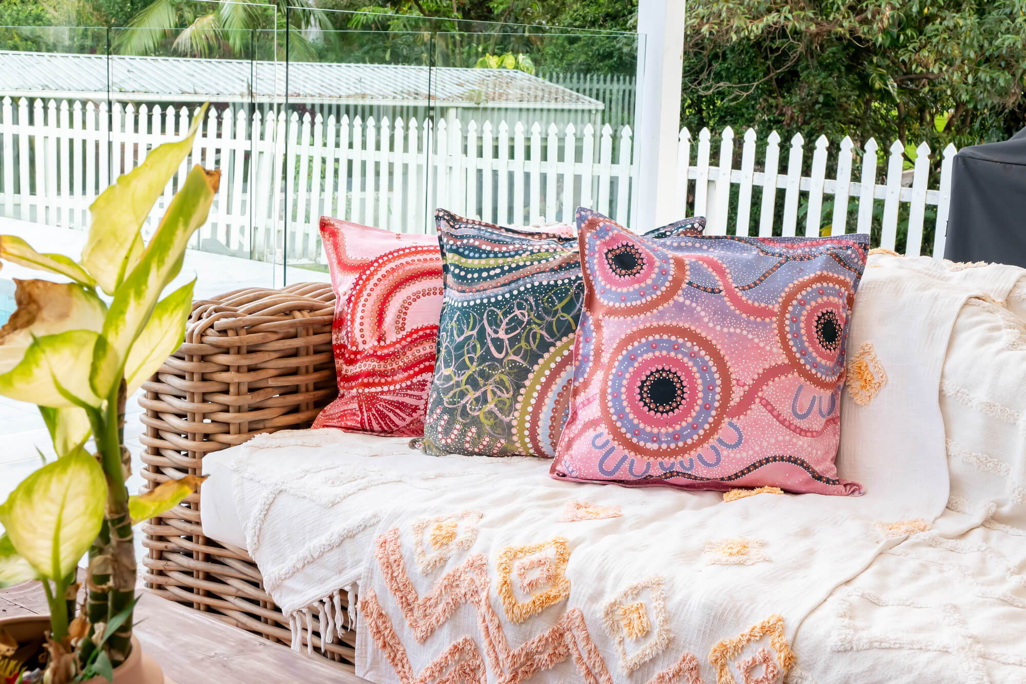3 cushions on a sofa with different artworks by the same Indigenous artist