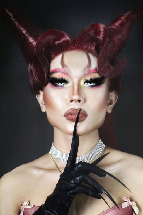 model with red hair forming 2 horns at the top of their head