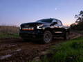 black chevrolet silverado with led light bar behind the grille for off road