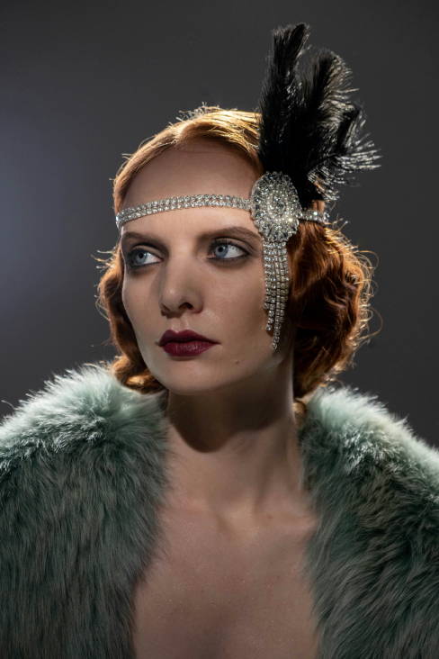 woman dresses as a flapper with short messy hair and a jeweled headband